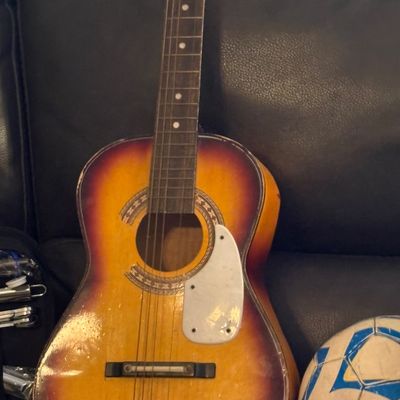 Sale Photo Thumbnail #53: Vintage sunburst acoustic parlor guitar with a white pickguard, patterned soundhole rosette, and visible wear.