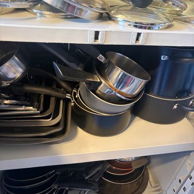 Sale Photo Thumbnail #81: Assorted collection of modern cookware, including stainless steel and non-stick pots, pans, baking sheets, and glass pot lids.
