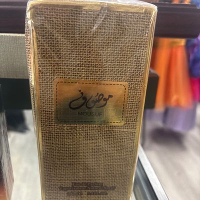 Sale Photo Thumbnail #130: Sealed box of Mousuf Eau de Parfum by Ard Al Zaafaran, 100ml / 3.4 fl oz, featuring a gold and woven-textured package design.