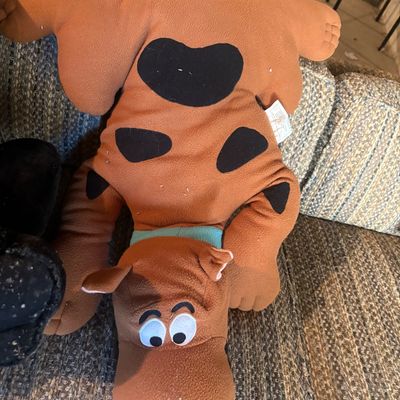 Sale Photo Thumbnail #90: Vintage Scooby-Doo Pillow Pet style plush toy resting upside down on a couch, featuring fleece fabric and embroidered details.