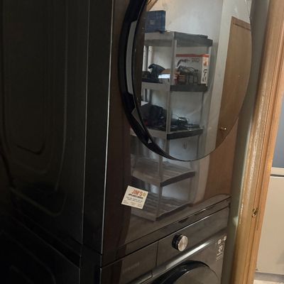 Sale Photo Thumbnail #33: Modern Samsung stacked front-load washer and dryer unit in a dark stainless steel finish.
