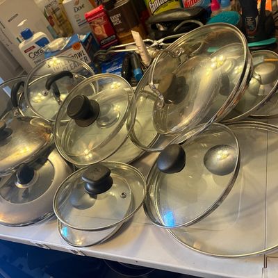Sale Photo Thumbnail #73: Large collection of assorted cookware lids, including glass and stainless steel varieties in various sizes.