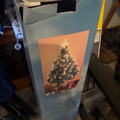 Sale Photo Thumbnail #46: Vintage artificial Christmas tree in its original, worn cardboard box featuring a star topper and clip-on lights.