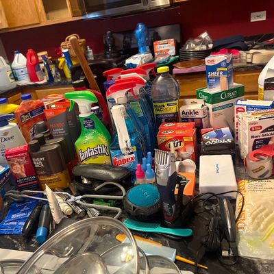 Sale Photo Thumbnail #76: Large assortment of household cleaning supplies, personal care products, first aid items, and grooming tools on a counter.