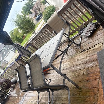 Sale Photo Thumbnail #15: Outdoor patio dining set featuring a tile-top table and metal-framed mesh chairs, situated on a wooden deck under a gazebo structure.