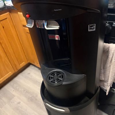 Sale Photo Thumbnail #5: Black bottom-loading water dispenser with hot and cold push levers and Energy Star certification.