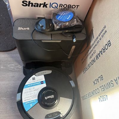 Sale Photo Thumbnail #63: Shark IQ Robot self-emptying vacuum with charging dock, accessories, and original signage.