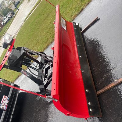 Sale Photo Thumbnail #39: Red Western snow plow attachment mounted on a vehicle frame, featuring a steel cutting edge, guide markers, and integrated headlights.