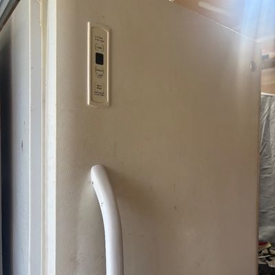 Sale Photo Thumbnail #38: Vintage white GE upright freezer featuring a front-door digital control panel and handle.