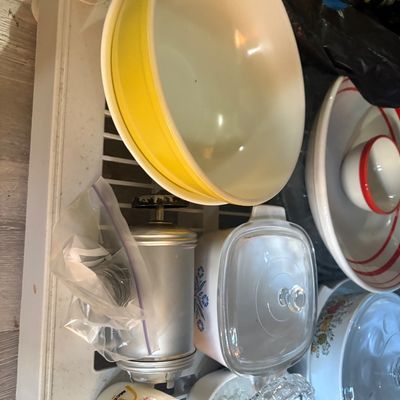 Sale Photo Thumbnail #59: Collection of vintage kitchenware including yellow Pyrex nesting bowls, a CorningWare Cornflower Blue casserole dish with lid, and a vintage McDonald's glass mug.