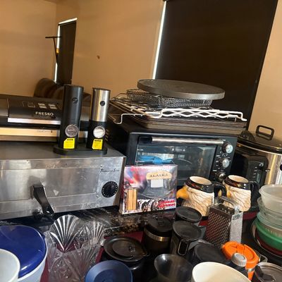 Sale Photo Thumbnail #16: Assortment of modern kitchen appliances and housewares, including a Fresko vacuum sealer, countertop toaster oven, electric salt and pepper grinders, and various glassware and mugs.
