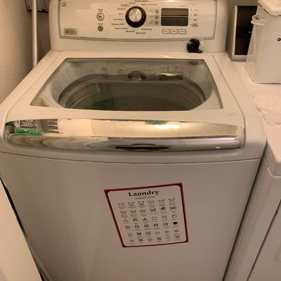 Sale Photo Thumbnail #81: GE Profile top-load washing machine with a glass-window lid, digital control panel, and chrome trim accents.