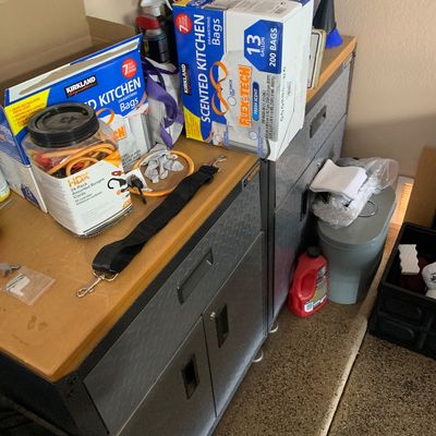 Sale Photo Thumbnail #121: Gladiator workbench and tool cabinet topped with various household items, including Kirkland kitchen trash bags and a jar of bungee cords.