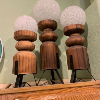 Sale Photo Thumbnail #66: Trio of mid-century rustic accent lamps featuring chunky turned wood bases, black metal tripod legs, and crushed glass orb shades.