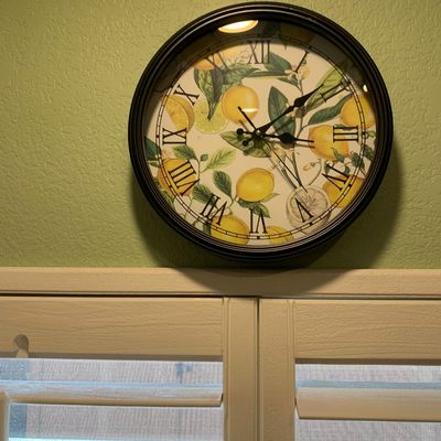 Sale Photo Thumbnail #75: Round wall clock with a black frame and a botanical lemon print face featuring Roman numerals.