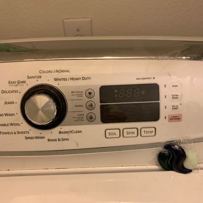 Sale Photo Thumbnail #83: Control panel of a modern top-load washing machine with digital display and metallic selection dial.