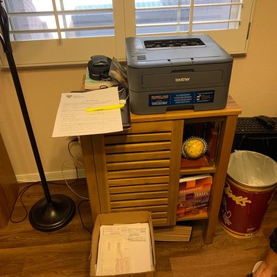 Sale Photo Thumbnail #87: Brother laser printer displayed on a wooden cabinet alongside office supplies and decorative shelf items.