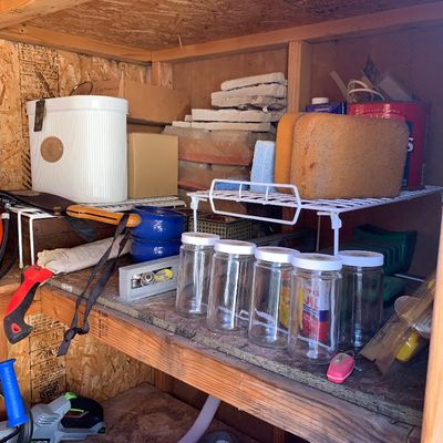 Sale Photo Thumbnail #23: Storage shed shelves organized with various household and workshop items, including glass jars, power tools, cleaning sponges, and hardware accessories.
