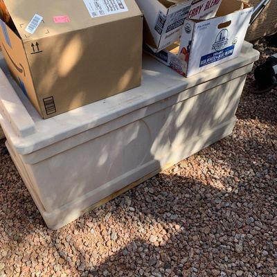 Sale Photo Thumbnail #26: Off-white plastic outdoor deck storage box, shown with several cardboard packing boxes stacked on top outdoors.