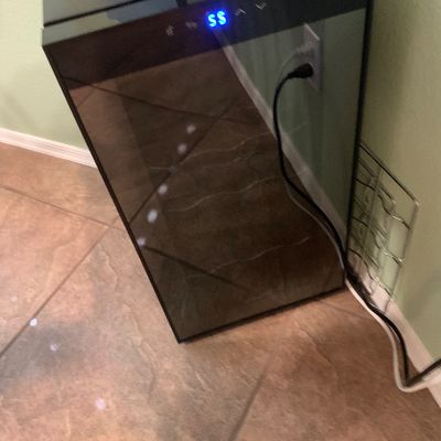 Sale Photo Thumbnail #62: Modern black freestanding wine cooler featuring a digital temperature display and glass front door.