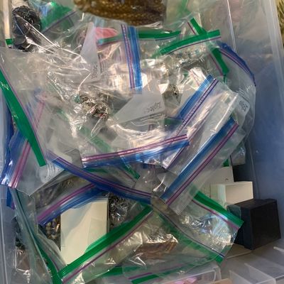 Sale Photo Thumbnail #97: Large clear plastic storage bin filled with sorted costume jewelry packaged in ziplock bags.