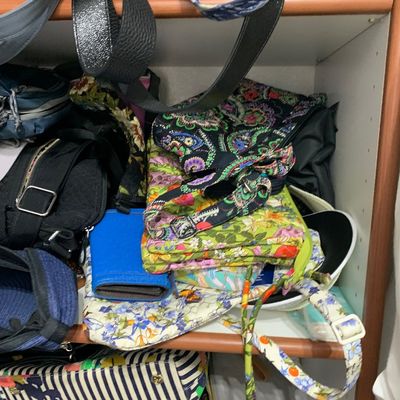 Sale Photo Thumbnail #112: A large collection of assortment purses, totes, and handbags packed on closet shelves, including various Vera Bradley quilted floral patterns and leather bags.