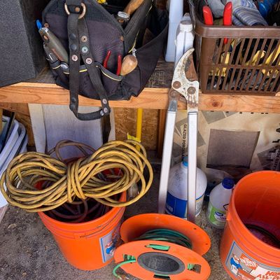 Sale Photo Thumbnail #20: Collection of workshop and gardening tools including heavy-duty extension cords, a tool bag with hand tools, loppers, and Home Depot 5-gallon buckets.