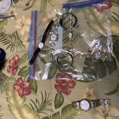 Sale Photo Thumbnail #98: Collection of assorted women's wristwatches, including leather strap, silver-tone link, and decorative metal band designs displayed on a floral surface.
