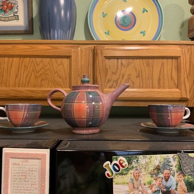 Sale Photo Thumbnail #65: Hand-painted plaid ceramic teapot set featuring a matching teapot and two teacups with saucers, displayed on a counter.