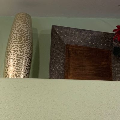 Sale Photo Thumbnail #78: Metallic gold-finished leopard print floor vase displayed alongside a dark wood decorative tray with embossed metal trim.