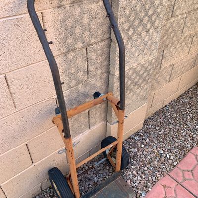 Sale Photo Thumbnail #16: Vintage orange and black convertible hand truck and utility cart with rubber wheels, showing surface rust and wear from use.