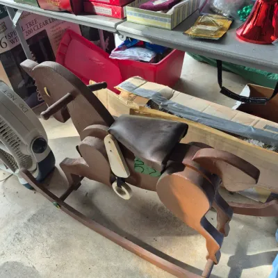 Sale Photo Thumbnail #34: Vintage handmade wooden rocking horse with a dark faux-leather padded seat and stirrups.