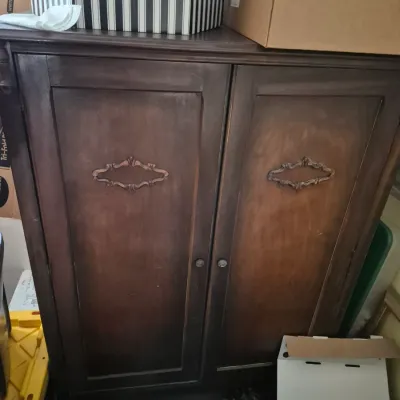 Sale Photo Thumbnail #61: Vintage dark stain wooden cabinet featuring decorative carved scrollwork on double front doors.