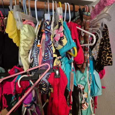 Sale Photo Thumbnail #66: Closet filled with various modern women's swimwear, bikinis, and cover-ups on plastic hangers.