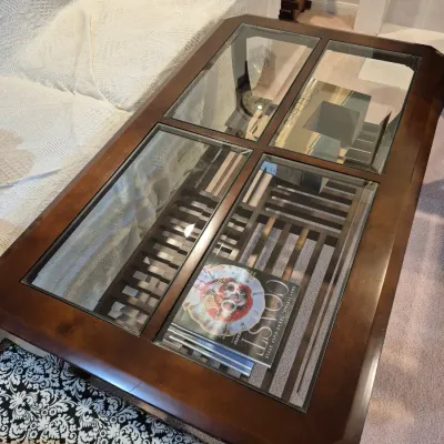 Sale Photo Thumbnail #71: Dark wood coffee table featuring four glass-insert panels and a slatted lower display shelf.