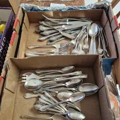 Sale Photo Thumbnail #18: Large collection of vintage silverplate flatware, including various spoons, forks, and knives, organized in cardboard trays.