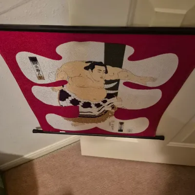 Sale Photo Thumbnail #49: Japanese fabric wall scroll banner depicting a sumo wrestler in a ceremonial stance, mounted on black hanging rods.