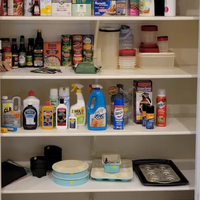 Pantry closet filled with assorted household cleaning products, packaged food items, Tupperware containers, and bakeware.
