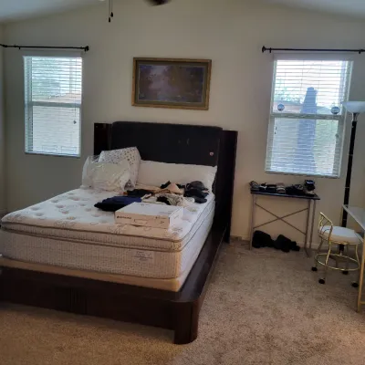 Contemporary dark wood queen bed frame with mattress, along with assorted bedroom furniture, framed wall art, and household items.