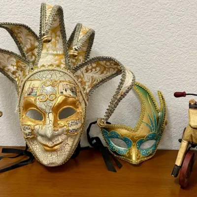 
Venetian Jester Mask, Blue And Gold Eye Mask, And A Wooden Toy Horse On Wheels