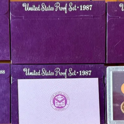 
(5) 1987 US Proof Sets With Paperwork And (1) 1988 US Proof Sets With Paper Work