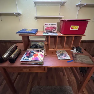 Sale Photo Thumbnail #32: Wooden desk display featuring Monogram '57 Corvette model kit, vintage brass fire extinguishers, a Buffalo Tools plastic bin, vinyl records, and framed artwork.
