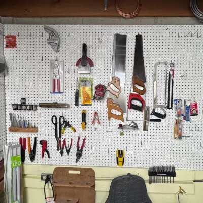 Sale Photo Thumbnail #51: Workshop wall organizer pegboard featuring an assortment of hand tools, including hand saws, hacksaws, pliers, wire strippers, scrapers, and a Stanley stud finder.