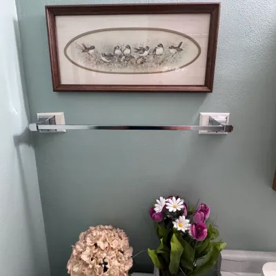 Sale Photo Thumbnail #23: Framed Bird Print Art and Artificial Floral Decor | Home Decor / Wall Art: A vintage framed oblong art print featuring perched birds in a dark wood frame, displayed above a chrome towel bar and decorative faux hydrangea and tulip arrangements.