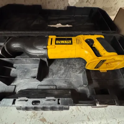 Sale Photo Thumbnail #57: Title: DeWalt Cordless Reciprocating Saw with Hard Case | Categories: Tools & Hardware, Power Tools | DeWalt cordless reciprocating saw in classic yellow and black casing, resting in its fitted black plastic storage case showing light cosmetic wear from u