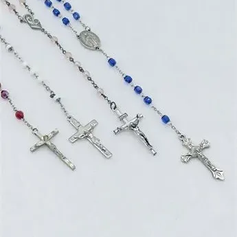 Sale Photo Thumbnail #33: Four Catholic rosary necklaces featuring colored glass and crystal beads with silver-tone crucifixes and center medals.
