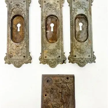 Sale Photo Thumbnail #31: Set of three antique Victorian ornate door keyhole backplates alongside a cast iron mortise lock depicting a relief scene.