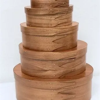 Sale Photo Thumbnail #45: Stacked set of five Shaker-style oval pantry boxes crafted from natural wood with traditional swallowtail joints and copper tacks.