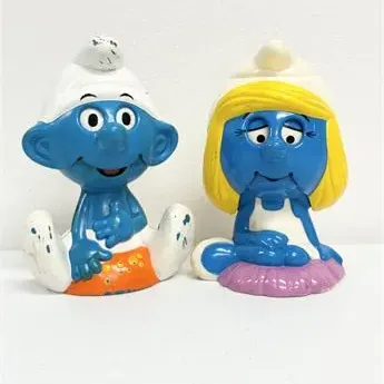 Sale Photo Thumbnail #25: Vintage 1980s Smurf and Smurfette hard plastic coin banks, showing minor paint wear and scuffing from use.