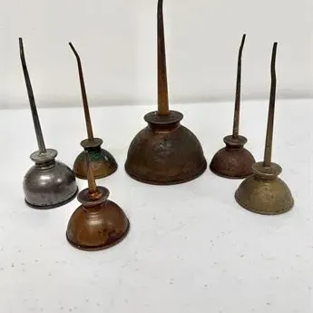 Sale Photo Thumbnail #30: Collection of six vintage metal thumb-push oil cans with long spouts, showing patina and age-appropriate wear.